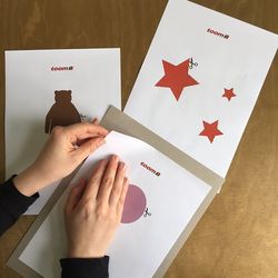 Hände positionieren Papier mit Formen auf Pappe